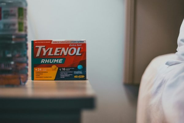 a bottle of tylenol next to a bed